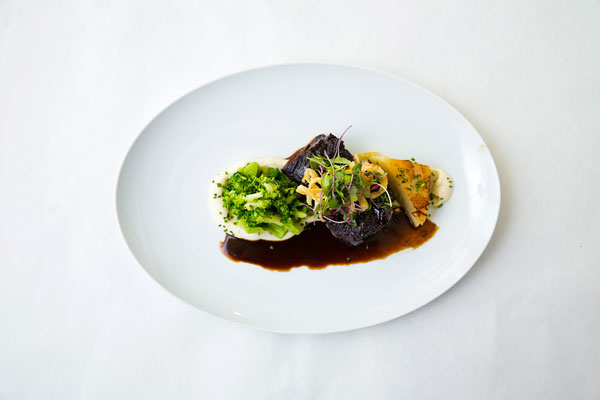overview view of steak topped with crispy onions and sprouts with sides of mashed potatoes and broccoli